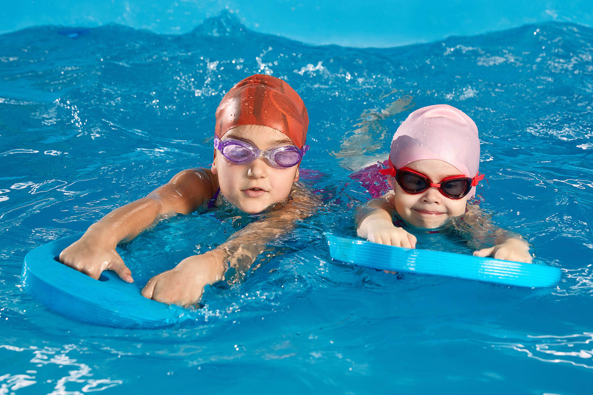 Kinder mit Schwimmbrettern mit Wasser
