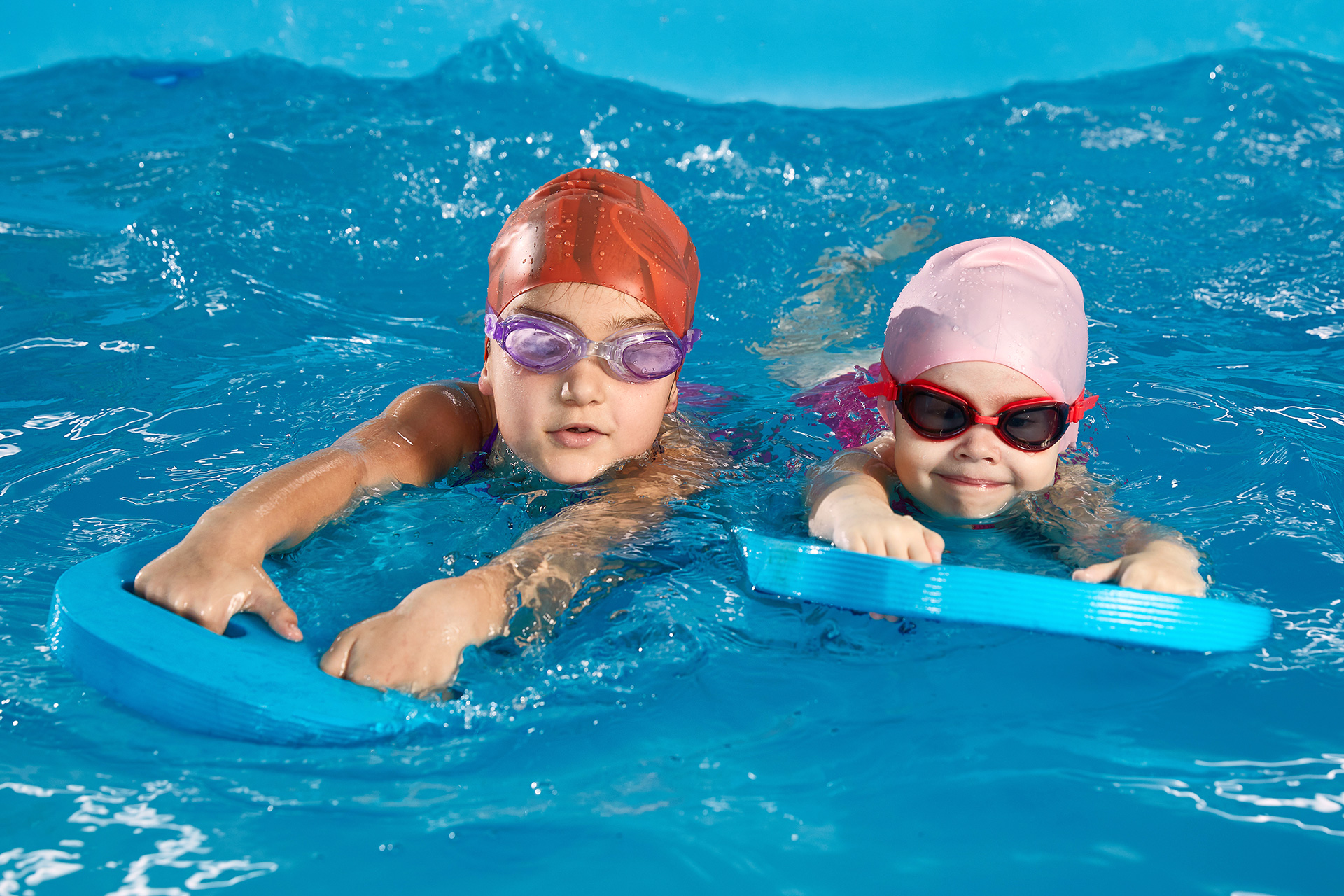 Schwimmkurse für Kinder Kinder mit Schwimmbrettern mit Wasser